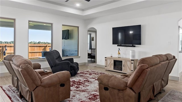 living room with a tray ceiling and light hardwood / wood-style flooring