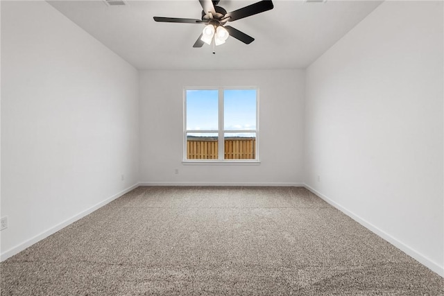 unfurnished room with carpet floors, ceiling fan, visible vents, and baseboards