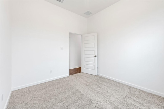 carpeted empty room with visible vents and baseboards