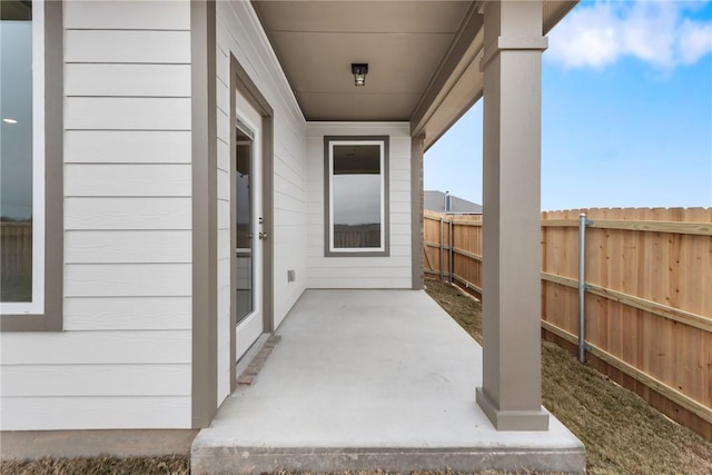 property entrance with a patio area and fence