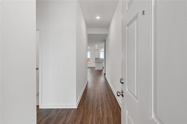 hallway with baseboards and dark wood finished floors