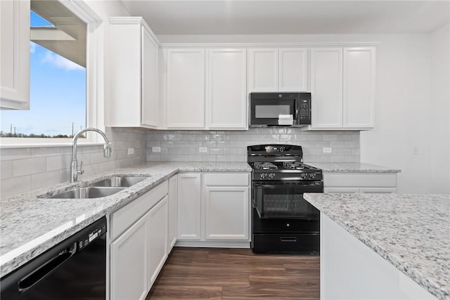 kitchen with white cabinets, a sink, and black appliances