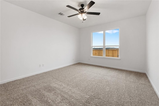 empty room featuring ceiling fan, carpet floors, visible vents, and baseboards