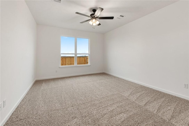 empty room with carpet flooring, visible vents, and baseboards