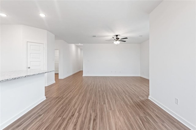 empty room with baseboards, recessed lighting, a ceiling fan, and light wood-style floors