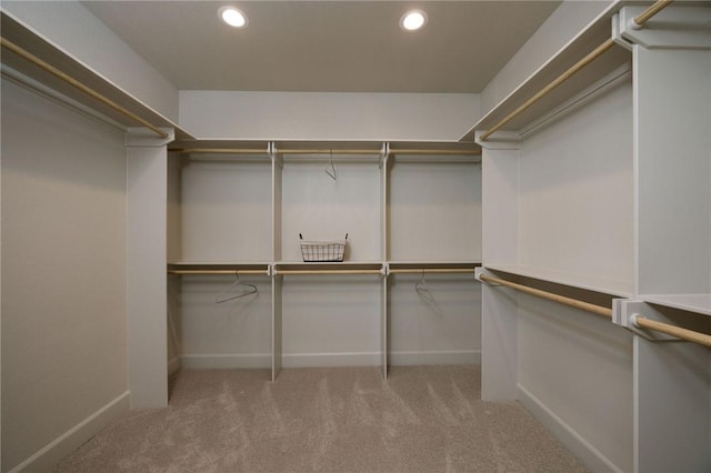 walk in closet with light carpet