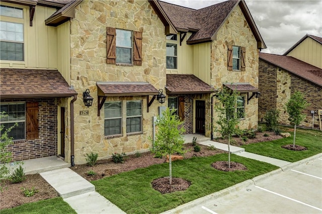 townhome / multi-family property featuring board and batten siding, uncovered parking, and stone siding