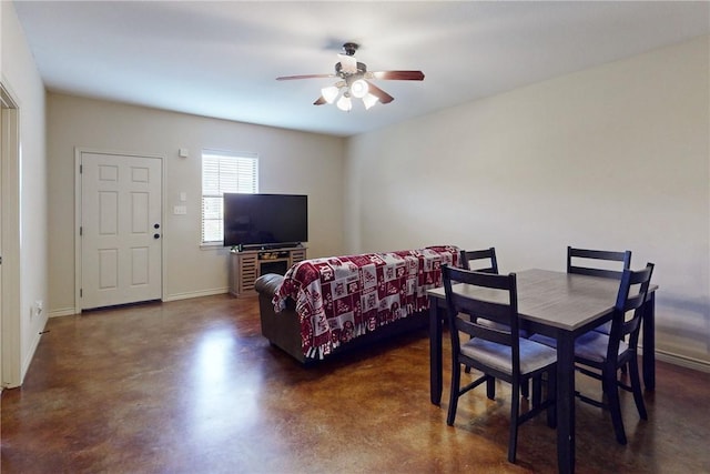 dining room featuring ceiling fan, baseboards, and finished concrete floors