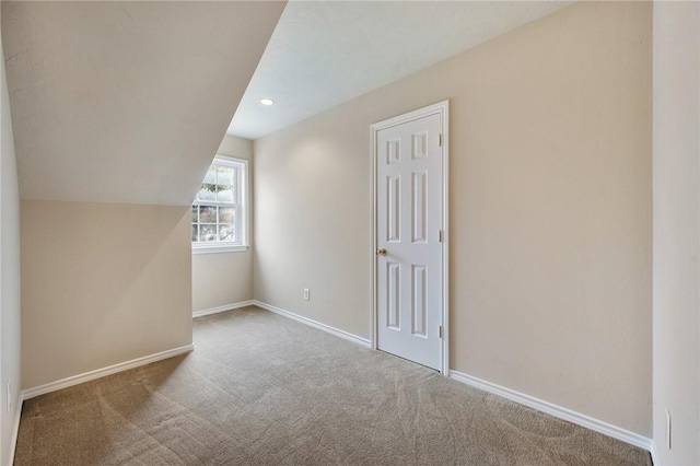 bonus room with baseboards, vaulted ceiling, and carpet flooring