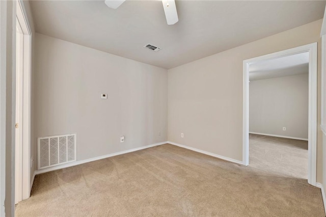 spare room with carpet, visible vents, ceiling fan, and baseboards