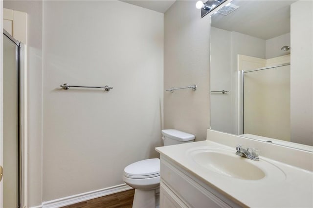 bathroom with visible vents, wood finished floors, a shower stall, and toilet