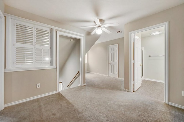 empty room featuring carpet floors, visible vents, ceiling fan, and baseboards