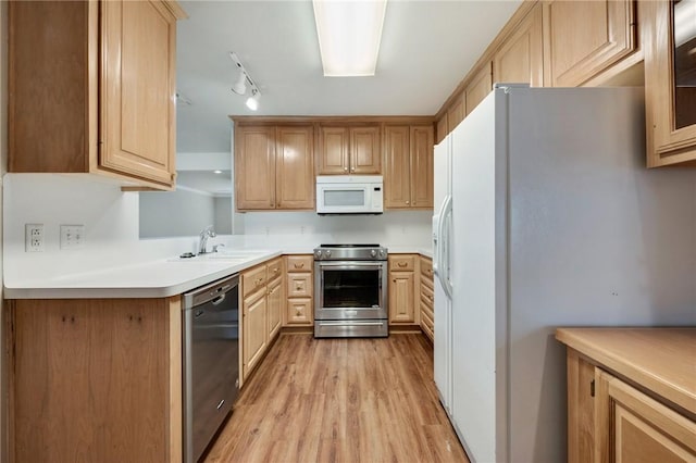 kitchen with light brown cabinets, a sink, light countertops, appliances with stainless steel finishes, and light wood-type flooring