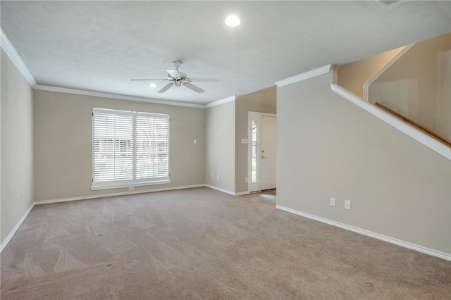 spare room with a ceiling fan, carpet, ornamental molding, and baseboards