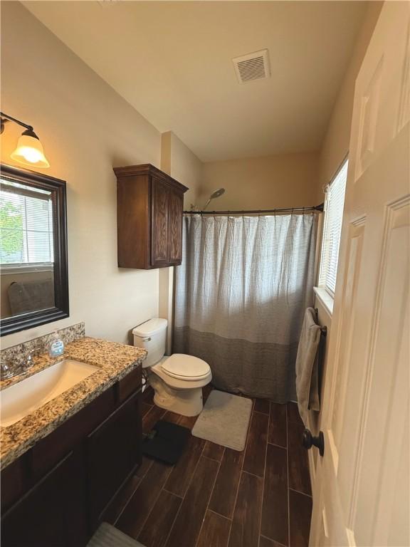 4008 Oaklawn St, Bryan, TX 77801 - full bathroom featuring wood tiled floors, toilet, vanity, and curtained shower