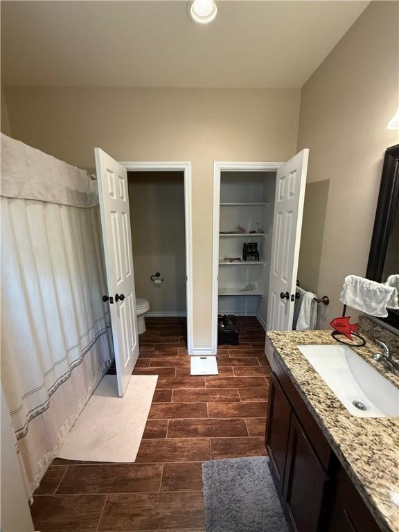 4008 Oaklawn St, Bryan, TX 77801 - full bath with wood finish floors, toilet, vanity, baseboards, and recessed lighting
