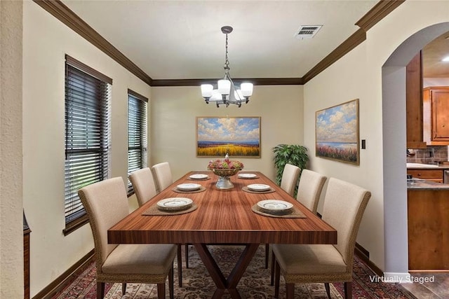 2409 Stone Castle Cir, College Station, TX 77845 - dining area with arched walkways, a chandelier, ornamental molding, and baseboards
