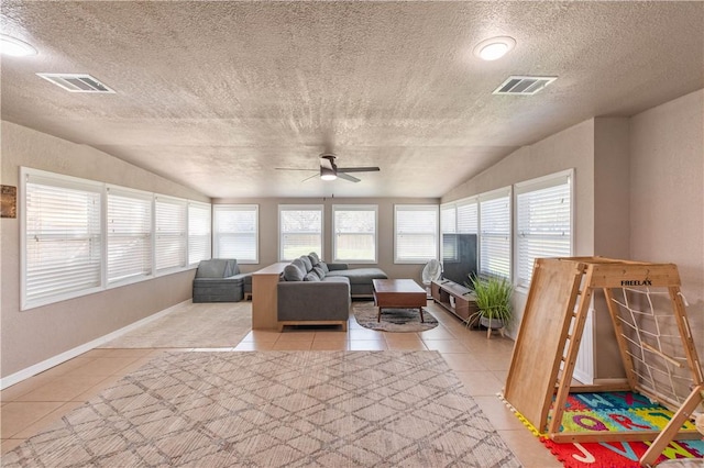 sunroom with lofted ceiling, a ceiling fan, and visible vents