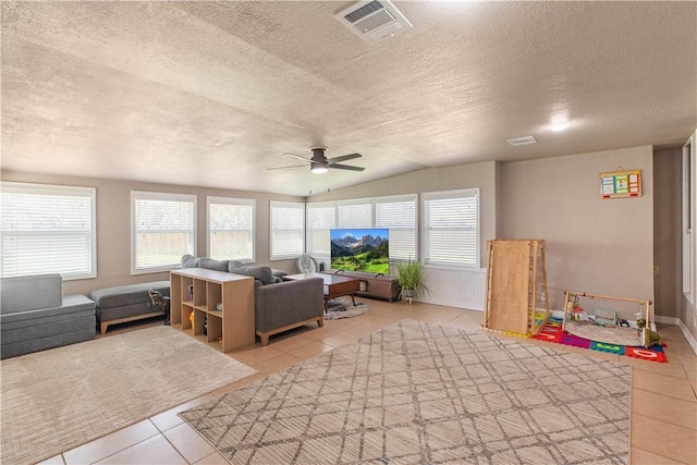 sunroom featuring visible vents, ceiling fan, and vaulted ceiling