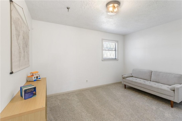 living area with baseboards, carpet floors, and a textured ceiling