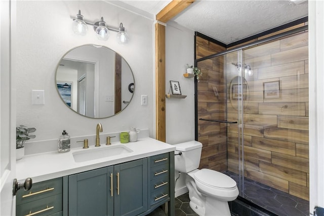 bathroom featuring vanity, toilet, a shower stall, and a textured ceiling