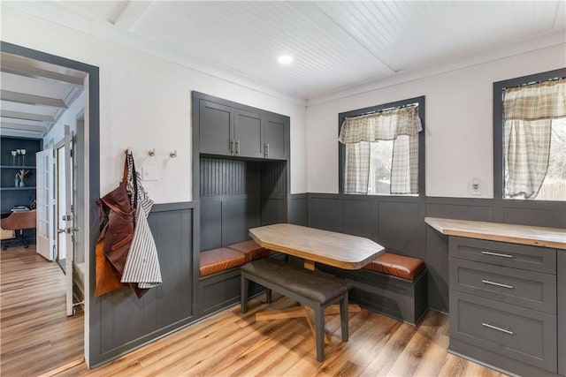 dining space featuring wainscoting, light wood finished floors, and breakfast area