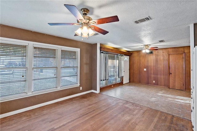 unfurnished living room featuring ceiling fan, wood-type flooring, and a textured ceiling