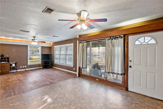 foyer featuring ceiling fan, wood-type flooring, and a textured ceiling