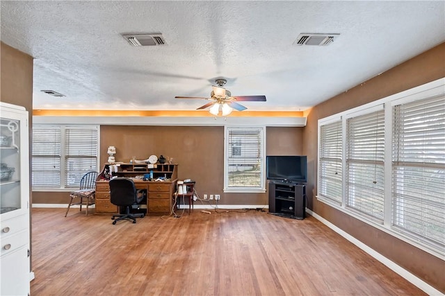 home office with hardwood / wood-style floors, a textured ceiling, and ceiling fan