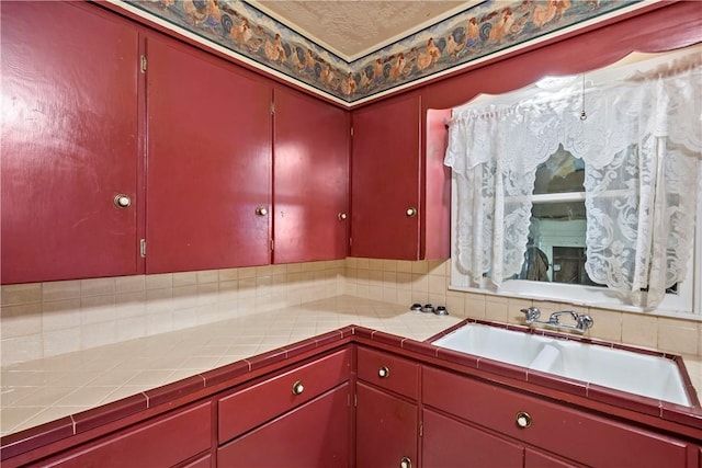 kitchen featuring tile counters and sink