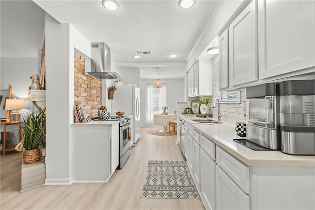 1203 Hawk Tree Dr, College Station, TX 77845 - kitchen with appliances with stainless steel finishes, wall chimney range hood, a sink, backsplash, and light countertops