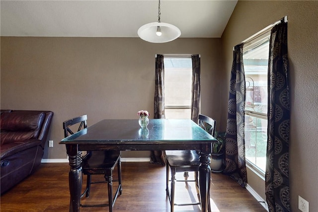 dining space with dark hardwood / wood-style flooring and lofted ceiling