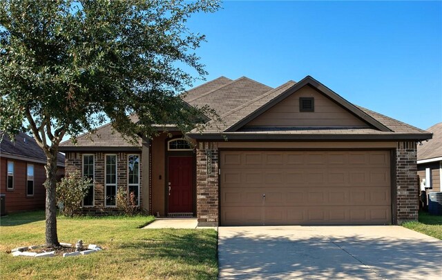 view of front of property featuring cooling unit, a garage, and a front yard