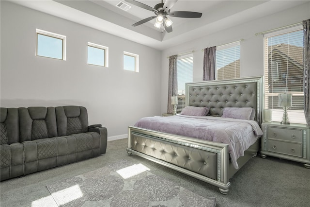 carpeted bedroom featuring multiple windows and ceiling fan