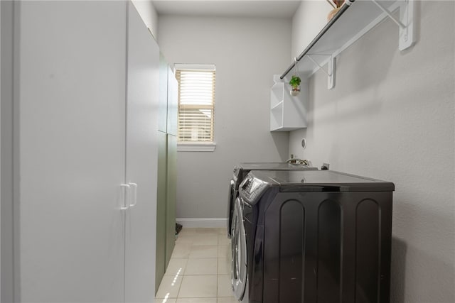 washroom featuring light tile patterned flooring and washing machine and clothes dryer