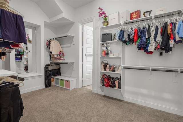 spacious closet featuring light colored carpet and vaulted ceiling