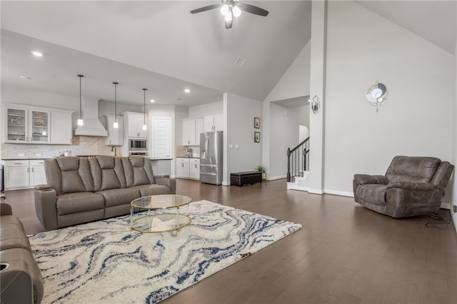 living room featuring ceiling fan, high vaulted ceiling, and dark wood-type flooring