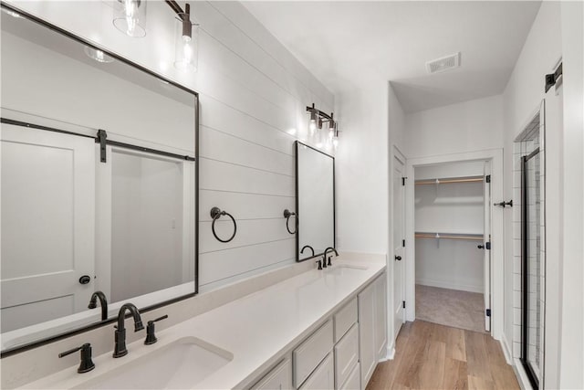 bathroom featuring a shower with door, vanity, and wood-type flooring