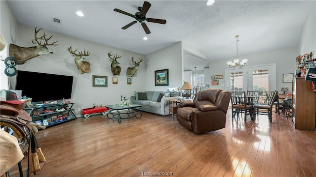 living room with hardwood / wood-style flooring, ceiling fan with notable chandelier, and lofted ceiling