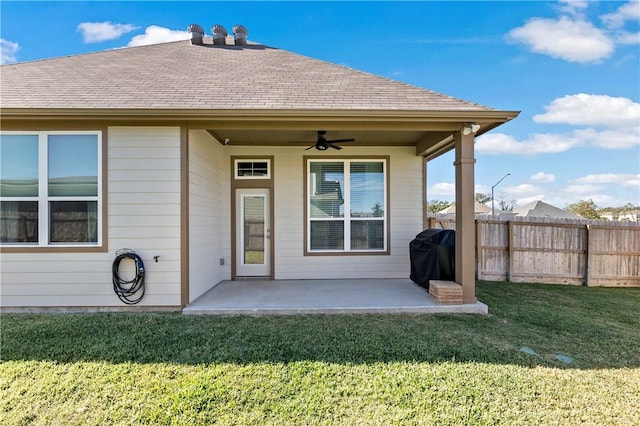 back of house featuring a lawn, ceiling fan, and a patio