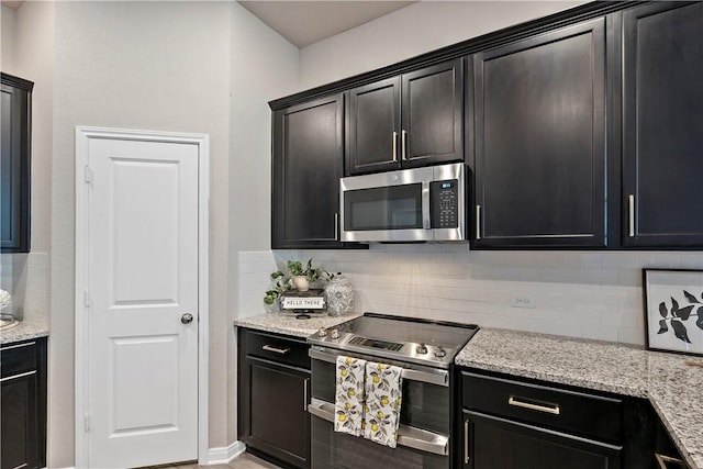 kitchen with decorative backsplash, light stone counters, and appliances with stainless steel finishes