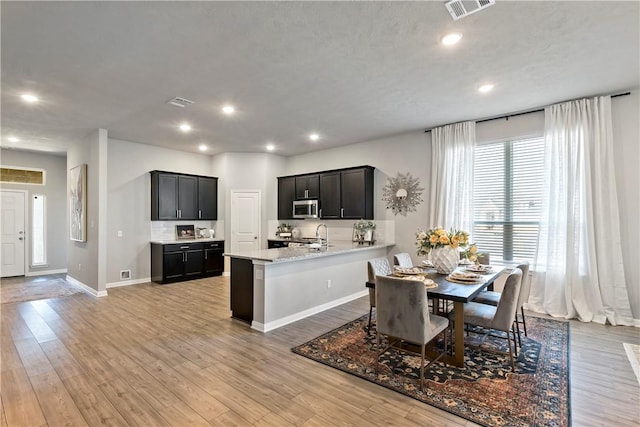 dining space with light hardwood / wood-style floors and a textured ceiling