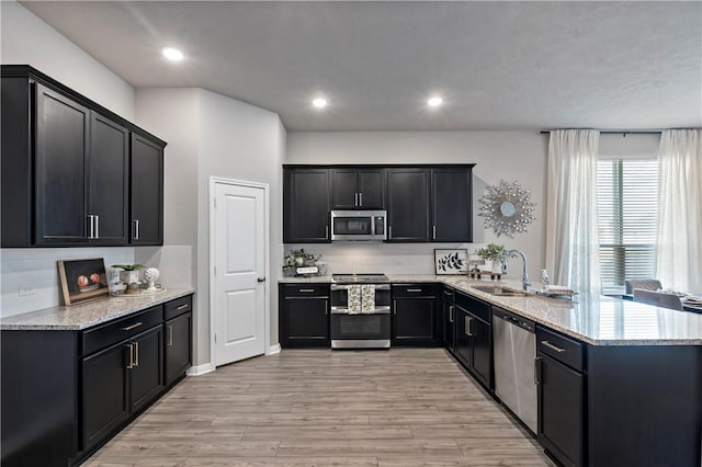 kitchen with plenty of natural light, sink, kitchen peninsula, and stainless steel appliances