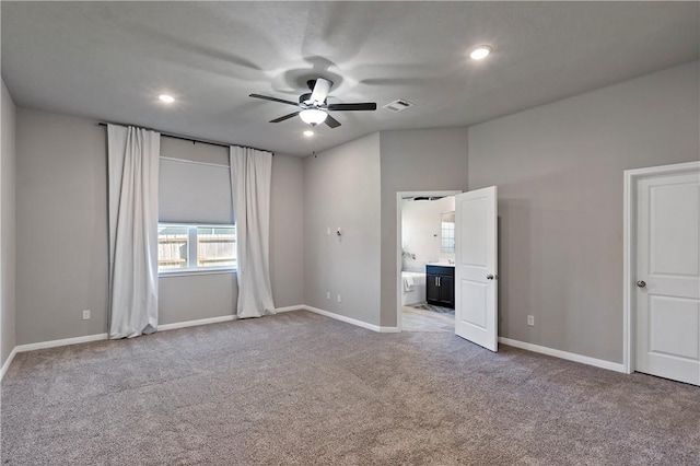 unfurnished bedroom with ceiling fan, light carpet, and connected bathroom