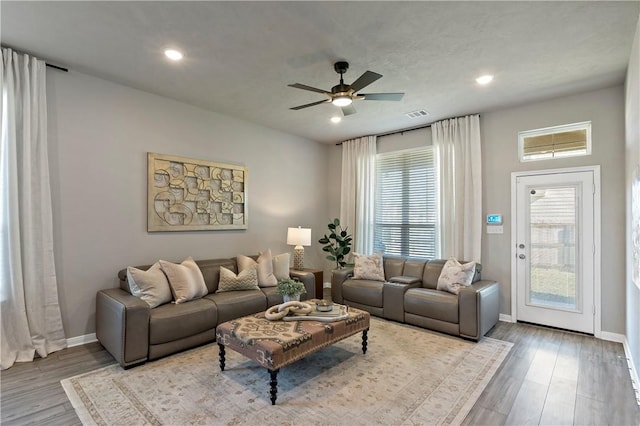 living room featuring hardwood / wood-style floors and ceiling fan