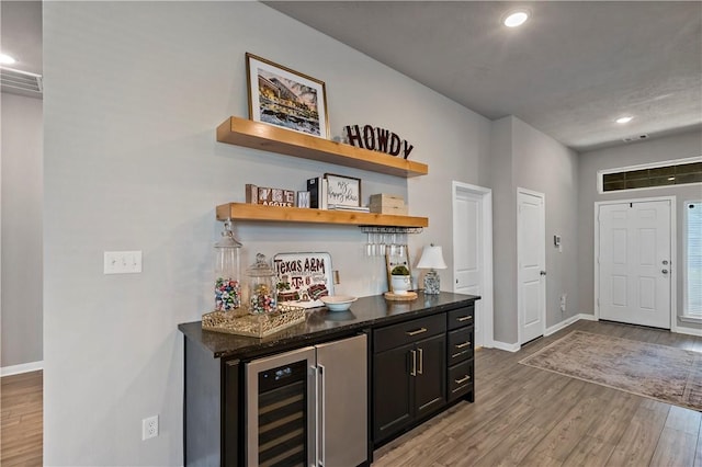 bar featuring wine cooler and light hardwood / wood-style flooring