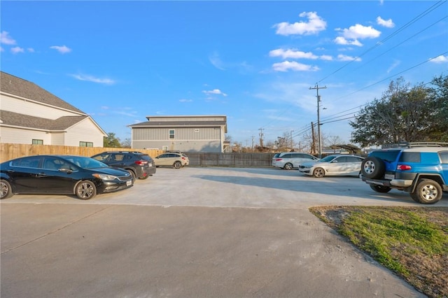 uncovered parking lot featuring fence