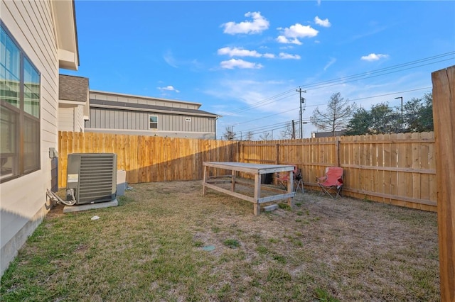 view of yard with central AC and a fenced backyard