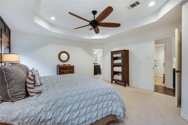 bedroom with baseboards, visible vents, recessed lighting, light carpet, and a raised ceiling