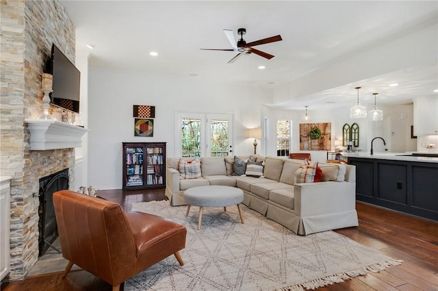 living area featuring recessed lighting, wood-type flooring, a ceiling fan, and a fireplace